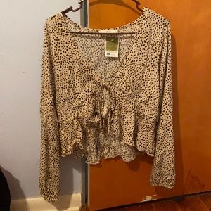 a spotted over shirt with a little tie in the front